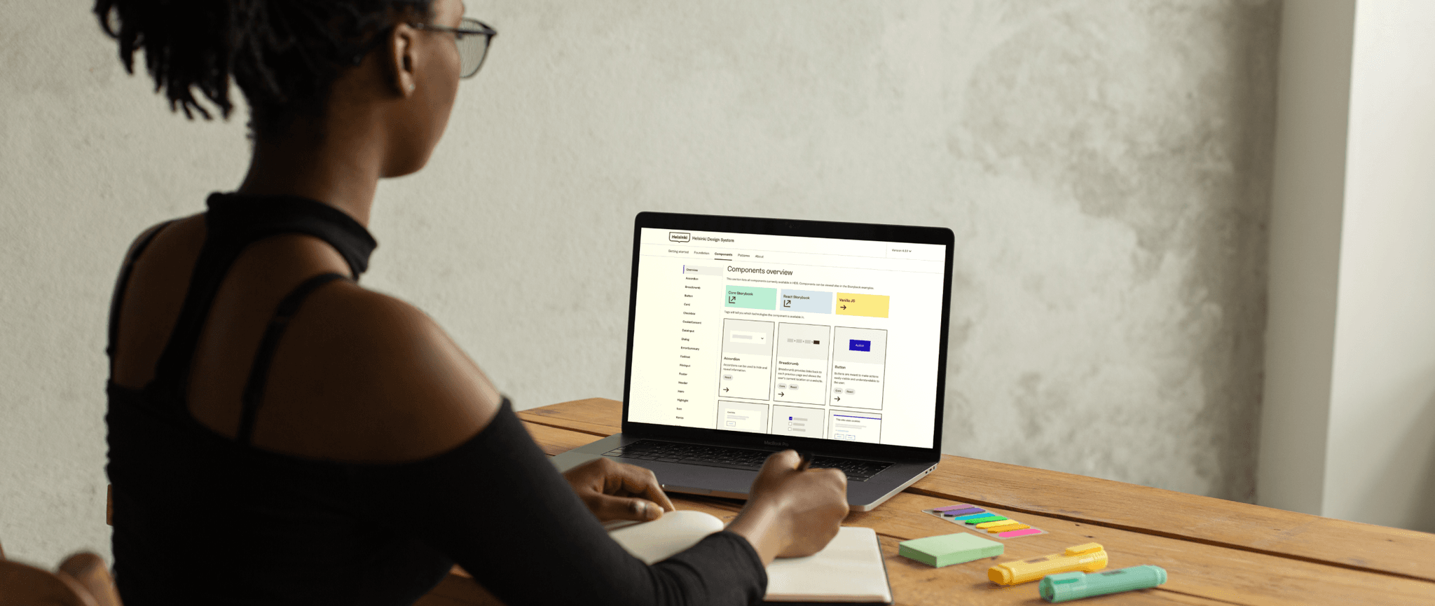 Person working at a laptop that shows the Helsinki Design System components documentation page